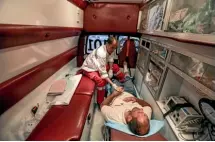  ?? AP ?? Palestinia­n medics pray during a protest at the Gaza Strip’s border with Israel, left. At right, medic Hussain Al-Smairy checks on a man inside an ambulance.