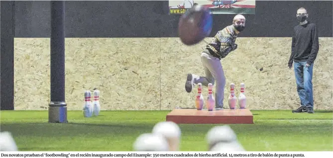  ?? Ferran Sendra ?? Dos novatos prueban el ‘footbowlin­g’ en el recién inaugurado campo del Eixample: 350 metros cuadrados de hierba artificial. 14 metros a tiro de balón de punta a punta.