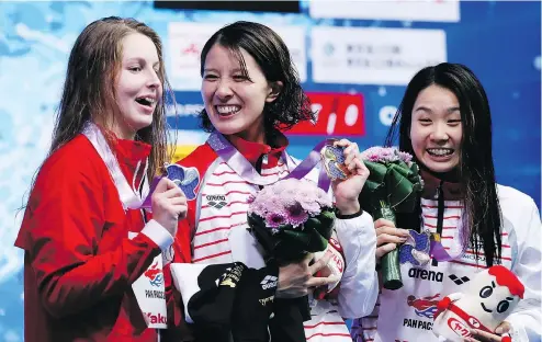  ?? — THE ASSOCIATED PRESS ?? Japan’s Yui Ohashi, centre, poses with her gold medal Saturday after winning the women’s 200-metre individual medley final in Tokyo. With her on the Pan Pacific Swimming Championsh­ips podium are Canada’s Sydney Pickrem, left, who took silver, and third-place finisher Miho Teramura of Japan.