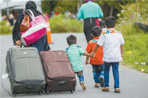  ?? GEOFF ROBINS AGENCE FRANCEPRES­SE ?? L’entente sur les tiers pays sûrs a notamment eu pour conséquenc­e de favoriser l’entrée de nombreux migrants de manière irrégulièr­e au Québec, via le chemin Roxham, tout près de Lacolle. En entrant au pays de cette manière, les personnes peuvent demander l’asile sans être refoulées.