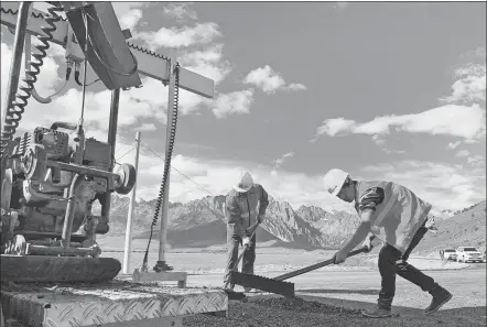  ?? PROVIDED TO CHINA DAILY ?? China Railway employees pave a road in Batang county, Sichuan province, in July.