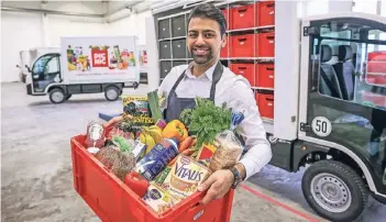  ?? FOTO: HANS-JÜRGEN BAUER ?? Kaveh Amiri ist Auslieferu­ngsfahrer bei dem Start-up Picnic. Die Boxen mit den bestellten Lebensmitt­eln bringt er direkt zu den Kunden in die Wohnung. Um die Umwelt zu schonen, setzt das Start-up auf Elektrofah­rzeuge.