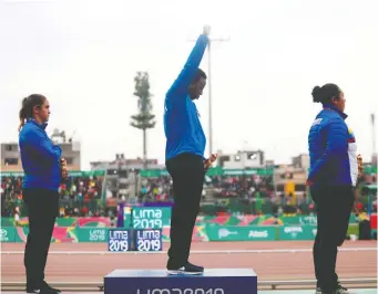  ?? CLAUDIO CRUZ/GETTY IMAGES ?? Gold medallist Gwen Berry raises her fist during the U.S. national anthem at the award ceremony following the hammer throw last Friday during the Pan Am Games in Lima, Peru.