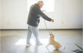  ??  ?? Jerrymonto­ya plays with his dog, Elvis, during Ainsley Price Day of Service for Veterans at Volunteers of America Bill Daniels Veteran Services Center on Saturday.