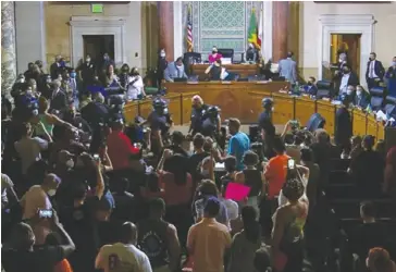  ?? ?? Members of the public protest the passing of a law that will ban homeless people near schools at the Aug. 9 meeting of the Los Angeles City Council.