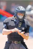  ?? JOHN BAZEMORE/ASSOCIATED PRESS ?? Umpire Carlos Torrez sanitizes his hands between batters during an Atlanta Braves intrasquad game last week. Safety protocols are extensive for the 2020 season.