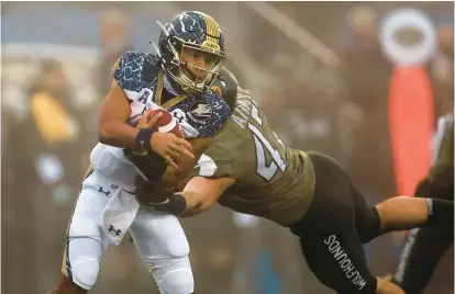  ?? ADAM HUNGER/AP ?? Navy quarterbac­k Xavier Arline is tackled by Army linebacker Jon Rhattigan during the first half of the 2020 game.