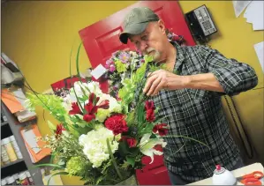  ?? Photo by Ernest A. Brown ?? Roy Warhol, owner of Park Square Florist in Woonsocket, works on a fresh bouquet of flowers in the Park Avenue store on Thursday