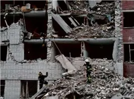  ?? GENYA SAVILOV/AFP VIA GETTY IMAGES ?? Ukrainian rescuers cleared the rubble of a destroyed building after a missile attack in Chernihiv on Wednesday.