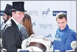  ?? (AFP) ?? Presentati­on of the trophy to the Godolphin team, Jockey William Buick (right), and trainer Charlie Appleby (left), after Masar wins the Derby on the second day of the Epsom Derby Festival in Surrey, southern England
on June 2.