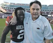  ?? Arkansas Democrat-Gazette file photo ?? Arkansas head coach Houston Nutt and cornerback Chris Houston walk off the field Sept. 23, 2006, after the Hogs’ 24-23 double overtime win over Alabama.