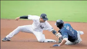  ?? Christian Petersen / Getty Images ?? The Yankees’ Gleyber Torres, left, tags out the Rays’ Yandy Diaz for a double play during the first inning of Game 4 of the American League Division Series on Thursday at Petco Park in San Diego.