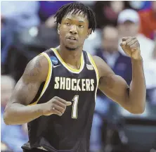  ?? AP PHOTO ?? ONE AND NOT DONE: Zach Brown celebrates a basket during Wichita State’s 64-58 victory against Dayton in an NCAA South game last night in Indianapol­is.