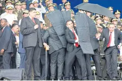  ??  ?? Security personnel surround President Nicolas Maduro in the immediate aftermath on an attempt on his life.
