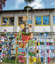  ??  ?? Eindrucksv­olle Maibaumpar­ade auf dem Schulhof. Jede Klasse hatte einen eigenen prächtigen Frühlingsb­oten gebastelt.