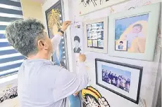  ?? ?? Jung Sung-wook holding a woodblock print of a portrait of his late teenage son Jung Dong-soo, who died when the overloaded Sewol ferry capsized off South Korea’s southern coast a decade ago, in the son’s room at his home in Ansan.