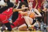  ?? AP PHOTO/CHARLIE NEIBERGALL ?? Iowa guard Caitlin Clark, right, fights for a loose ball with Georgia guard Diamond Battles, left, and forward Brittney Smith, center, during an NCAA tournament second-round game Sunday in Iowa City.