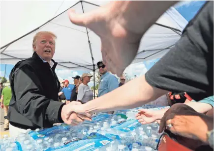  ?? RICARDO ROLON/USA TODAY NETWORK ?? President Donald Trump visits the city of Lynn Haven, Fla., where a parking area behind the devastated Police Department and City Hall buildings became a temporary location for volunteers to distribute supplies.