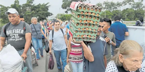  ?? EFE ?? Con todo. Un grupo de venezolano­s compra víveres y medicinas en Cúcuta y regresa a su país por el puente internacio­nal Simón Bolívar.