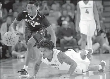  ?? NWA Democrat-Gazette/ANDY SHUPE ?? Arkansas guard Anton Beard dives on the floor as he tries to control a loose ball against Vanderbilt’s Saban Lee during Saturday’s victory in Fayettevil­le.