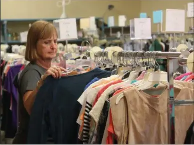  ?? CHARLES PRITCHARD - ONEIDA DAILY DISPATCH ?? Opportunit­y Shop President Barb Ortman looks over clothing at the shop on Thursday, June 20, 2019.