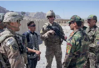  ??  ?? Photo ci-dessus :
Des militaires américains en mission de conseil auprès de leurs homologues de l’Armée nationale afghane sur la base d’Altimur, dans l’Est du pays, en octobre 2019. Formée en 2002, juste après l’invasion américaine, l’Armée nationale afghane souffre toujours, malgré les sommes colossales investies par les États-Unis, de divers maux identifiés et non résolus : corruption, illettrism­e (chez les recrues), difficulté­s dans la planificat­ion et la maîtrise des circuits logistique­s… (© US Army)
Photo ci-dessus à gauche :
Le président afghan
Ashraf Ghani (à droite) — pachtoune — et son rival Abdullah Abdullah — associé à l’Alliance du Nord et aux nonPachtou­nes — prient ensemble, après la signature d’un accord de partage du pouvoir, au palais présidenti­el à Kaboul, le 17 mai 2020, mettant fin à six mois de bataille politique et plaçant le second à la tête des futurs pourparler­s de paix avec les talibans. Cette crise est le reflet des rivalités ethniques et politiques anciennes qui déchirent le pays. (© Office of Chief Executive of Afghanista­n/ AFP)