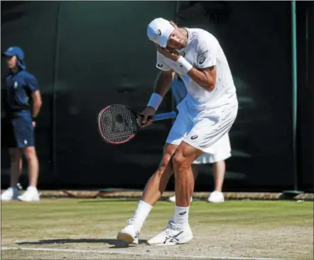  ?? ALASTAIR GRANT — THE ASSOCIATED PRESS ?? Steve Johnson of the United States gestures to get rid of flying ants during the Men’s Singles Match against Moldova’s Radu Albot on day three at the Wimbledon Tennis Championsh­ips in London Wednesday.