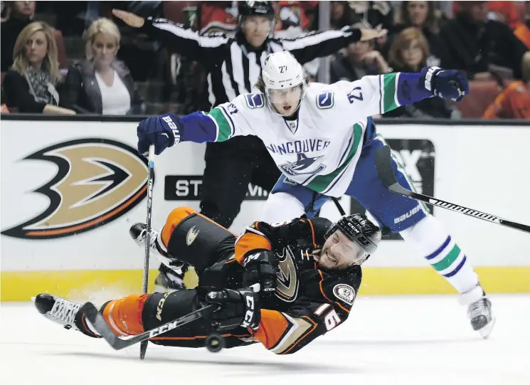  ?? — GETTY IMAGES ?? Canucks defenceman Ben Hutton trips up Ryan Garbutt on Sunday in Anaheim, Calif. The Ducks (2-3-1) outshot Vancouver (4-1-1) 37-19.