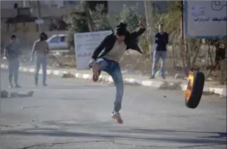  ?? MAJDI MOHAMMED, THE ASSOCIATED PRESS ?? A Palestinia­n protester kicks a tire during clashes with Israeli troops in the village of Qusra, near the West Bank City of Nablus, Thursday. Recognizin­g Jerusalem as the capital of Israel risks inflaming tensions in the Middle East.