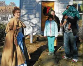  ?? BETSY SCOTT — THE NEWS-HERALD ?? The Olvera family, right, of Perry Township visited Century Village for the first time Nov. 26 to learn about Christmase­s past. The Christmas at Century Village program involved touring historic homes on site.