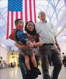  ?? JOE RAEDLE ?? A woman, identified only as Maria, carries her son Franco, 4, after being reunited as Ruben Garcia, director of the Annunciati­on House, escorts them at the El Paso Internatio­nal Airport on Thursday.