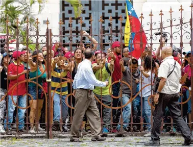  ?? THE ASSOCIATED PRESS ?? Pro-government supporters push on the entrance gate of the National Assembly in Caracas, Venezuela, Sunday. Government supporters interrupte­d a special congressio­nal session where lawmakers were discussing bringing legal charges against President...