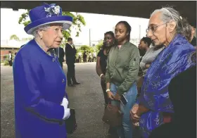  ?? AP/DOMINIC LIPINSKI ?? Queen Elizabeth II visits Friday with residents of Grenfell Tower who were displaced by Wednesday’s fire and are now staying at a shelter at a sports center in London.