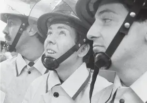  ?? ASSOCIATED PRESS FILE PHOTO ?? Brenda Berkman, center, watches a demonstrat­ion of firefighti­ng techniques with her male colleagues during graduation ceremonies Nov. 6, 1982, in New York. Berkman said she and the other women who were the first to join New York City’s fire department...