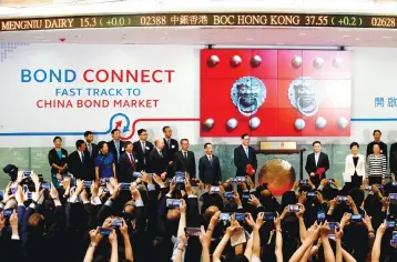  ??  ?? Hong Kong chief executive Carrie Lam, People’s Bank of China deputy governor Pan Gongsheng and Hong Kong Monetary Authority chief executive Norman Chan attend the launching ceremony of Bond Connect at Hong Kong Exchanges in Hong Kong. China yesterday...