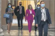  ?? JACQUELYN MARTIN - STAFF, AP ?? House Speaker Nancy Pelosi of California, center, walks to her office Monday on Capitol Hill in Washington.