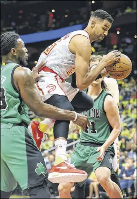  ?? CURTIS COMPTON / CCOMPTON@AJC.COM ?? The Hawks’ Thabo Sefolosha grabs an offensive rebound. Sefolosha was a factor on the boards, finishing with seven rebounds. Celtics point guard Isaiah Thomas makes a 3-pointer over the Hawks’ Thabo Sefolosha (right) and Jeff Teague. Thomas finished...