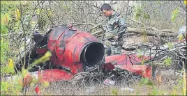  ?? PTI ?? An officer inspects the charred remains of an aircraft after two planes of IAF aerobatic team Surya Kiran crashed near the Yelahanka airbase in Bengaluru on Tuesday.