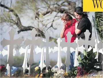  ?? SCOTT OLSON / GETTY IMAGES ?? Maria Durand, left, and her daughter Lupita Alcoces visit a memorial Tuesday where 26 crosses stand to honour the 26 victims killed in a mass shooting at the First Baptist Church of Sutherland Springs, Texas. Durand, who helps to teach Bible study at...