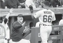  ?? GENE J. PUSKAR AP ?? Pirates’ Bligh Madris (66) is greeted at the dugout steps by manager Derek Shelton after driving in two runs with his first major league hit.