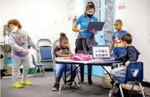  ?? Reuters ?? ↑
A learning pod teacher works with children as the Westcheste­r Family YMCA helps provide a safe distance learning environmen­t for local students in Los Angeles on Wednesday.