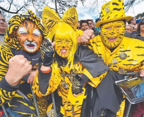  ??  ?? PAINT JOB: These Richmond fans found plenty to roar about during the AFL grand final parade in Melbourne yesterday. Picture: TONY GOUGH