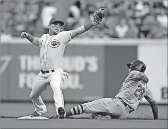  ?? [GARY LANDERS/THE ASSOCIATED PRESS] ?? Reds second baseman Scooter Gennett forces out the Cardinals’ Tommy Pham during the first inning.