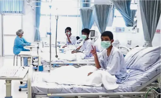  ?? — AP ?? We are fine: Three of the 12 boys greeting the world for the first time after being rescued from a cave in Chiang Rai.