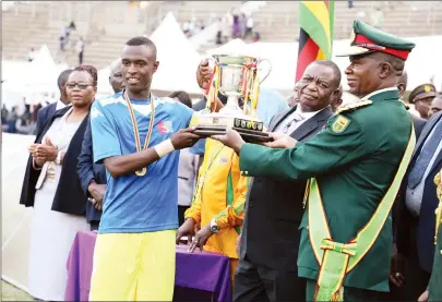  ??  ?? PROUD MOMENT ... ZDF Select captain Wonder Kapinda (left) receives the trophy from Commander Zimbabwe Defence Forces Phillip Valerio Sibanda while Vice President Constantin­o Chiwenga (centre) looks on at the National Sports Stadium yesterday.