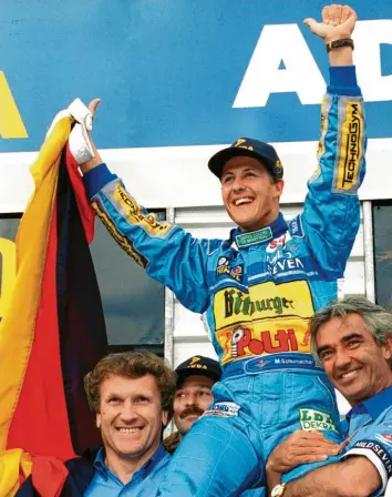  ?? Foto: Harry Melchert, dpa ?? Michael Schumacher genießt seinen großen Moment. Getragen von Flavio Briatore (rechts) feiert der Rennfahrer aus Kerpen am 13. November 1994 seinen ersten WM-Titel in der Formel 1. Es folgen noch sechs weitere.