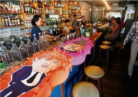  ?? — Reuters ?? A hit with supporters: Trump and Kim pinatas on display at Lucha Loco restaurant in Singapore.