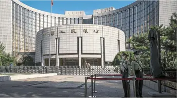  ?? — Bloomberg ?? Guiding hand: Guards are seen outside the PBOC building in Beijing. The central bank this week asked banks to stabilise lending to developers, in a bid to boost the country’s ailing property sector.