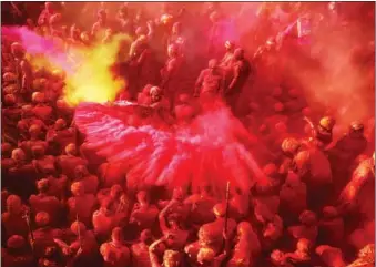  ?? ADNAN ABIDI / REUTERS ?? Hindu devotees take part in the religious festival of Holi inside a temple in Nandgaon village in Uttar Pradesh State, India, on March 12. Holi marks the end of winter in India and welcomes the spring season.