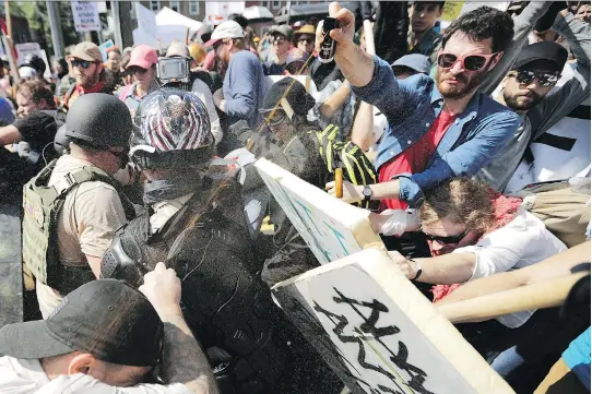  ?? CHIP SOMODEVILL­A/GETTY IMAGES ?? White nationalis­ts, neo-Nazis and members of the alt-right exchange volleys of pepper spray with counter-protesters at Charlottes­ville, Va., in August 2017: For Zeiger, the “path of questionin­g” began early. He says in a podcast that he was 14 when he...